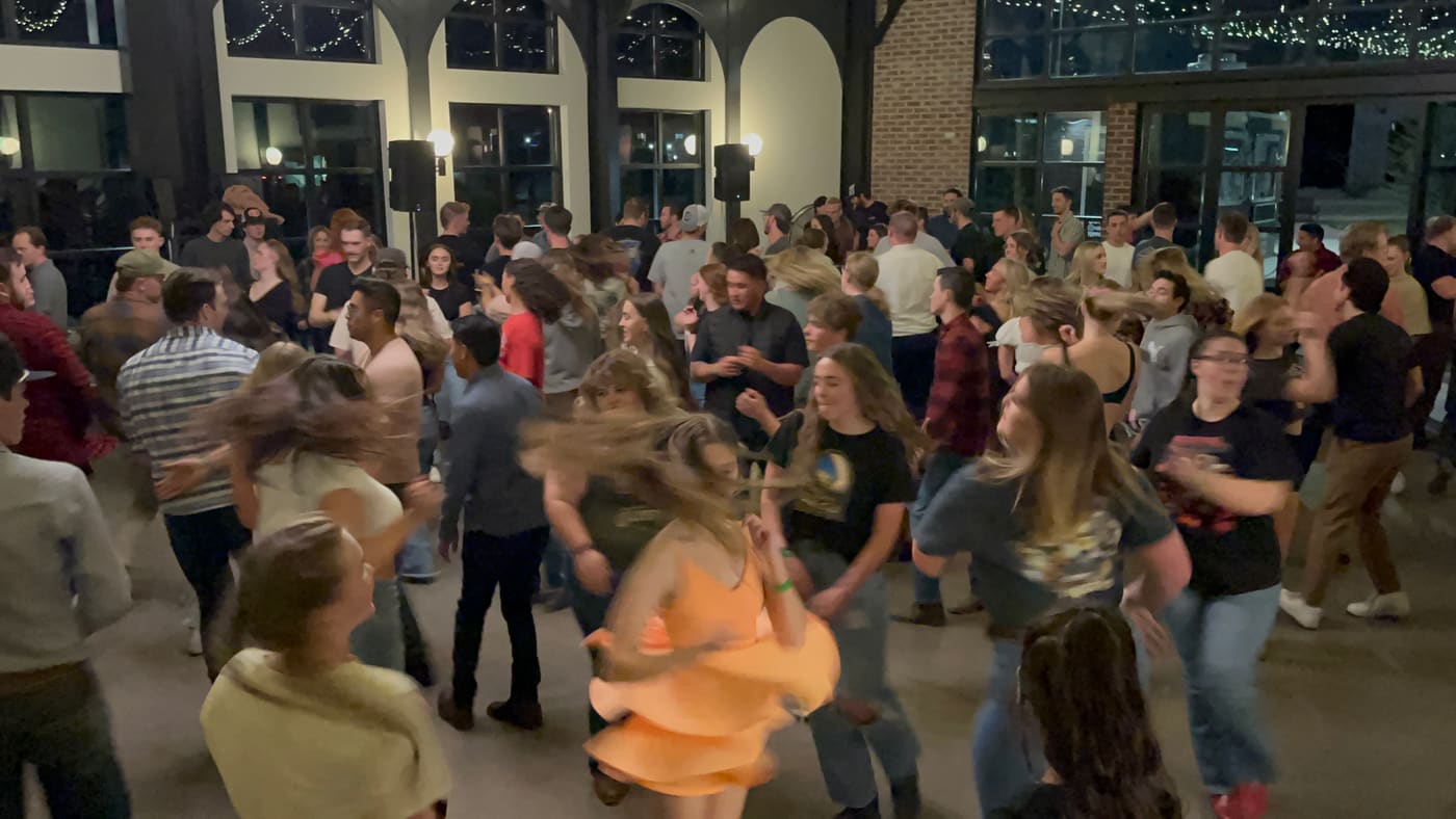 Couples spinning on a packed dance floor at Grove Station